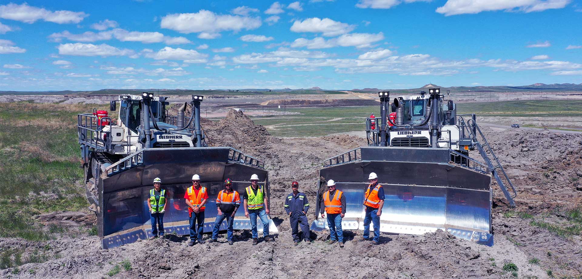 Belle Ayr Mine team standing in front of two white Liebherr PR 776 dozers