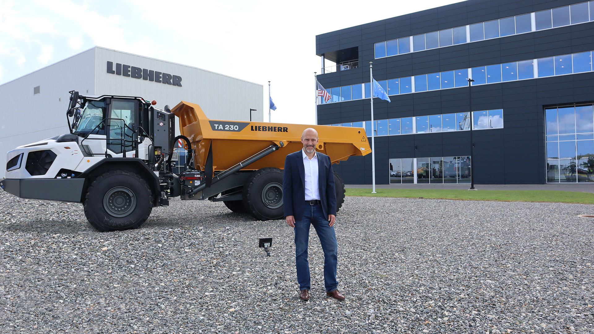 Kai Friedrich, Managing Director of Liebherr USA, Co. standing in front of the TA 230 articulated truck at the Newport News, Virginia campus.