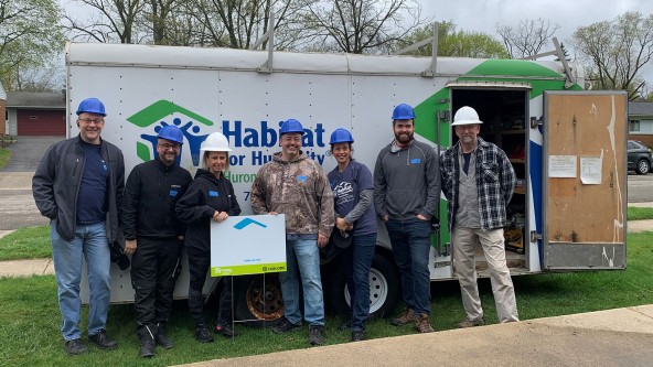 Liebherr USA, Co. sponsors Habitat for Humanity. Team standing in front of Habitat for Humanity trailer.