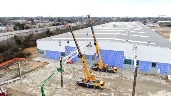 Prillaman Crane and Rigging utilizing a yellow Liebherr LTM 1090-4.2 mobile crane and a LTM 1250-5.1 mobile crane to complete a safe demolition at the back of the Liebherr Mining Newport News campus.